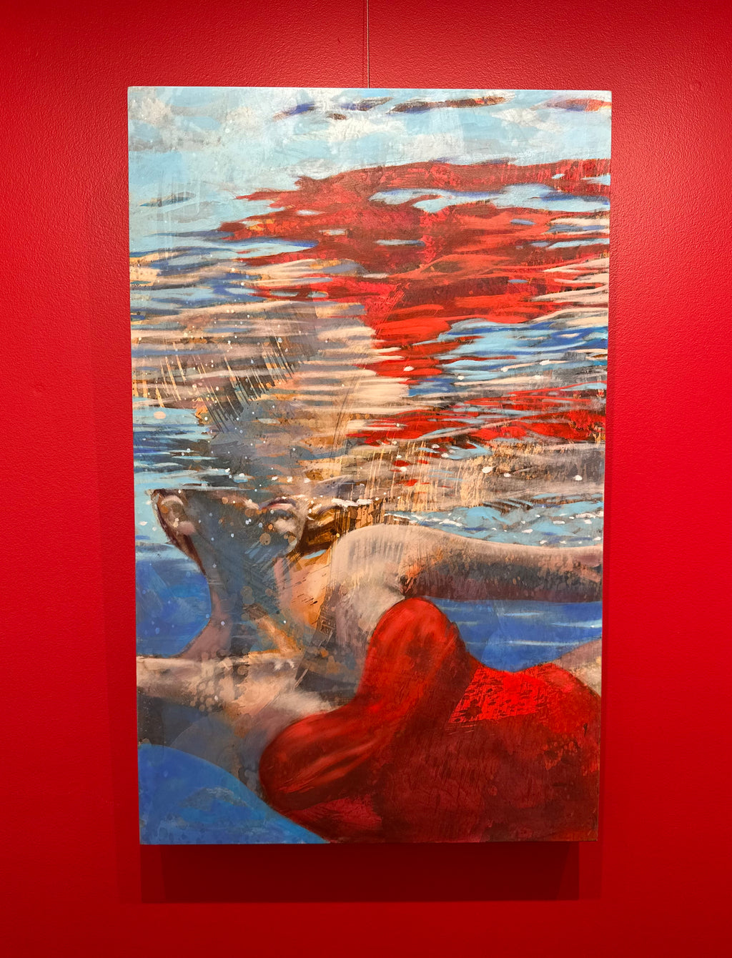 Underwater oil painting by Carol Bennett of a woman swimming on her side in a red bikini and sun peaking through water ripples