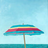 small scale oil painting of pink, yellow and turquoise beach umbrella with blue sky and ocean behind 