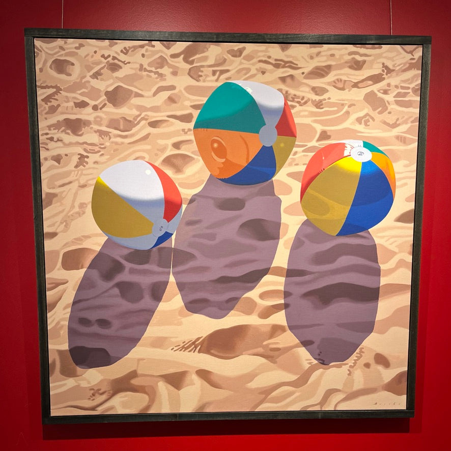 Photorealist oil painting of three beach balls in the sand
