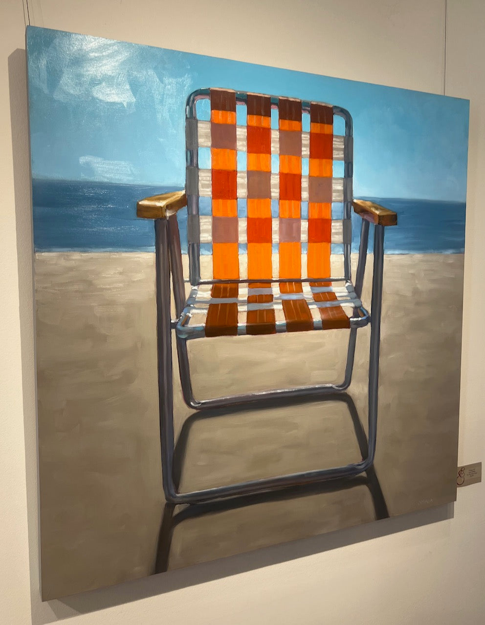 still life oil painting of an orange and white beach chair sitting in the sand in front of the ocean