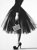 Black and white oil painting of a woman wearing a tulle skirt, heels, and a purse