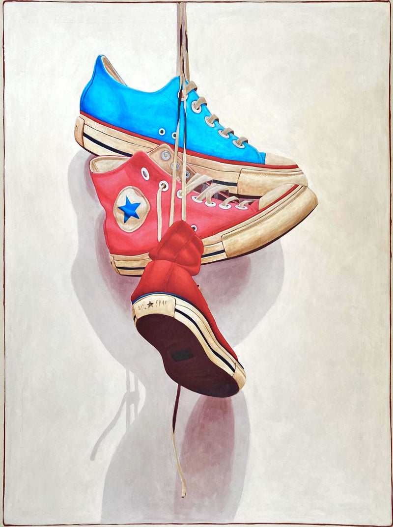 Still life oil painting by Santiago Garcia of a red, blue, and pink converse sneaker hanging by shoe laces on a white shadowed canvas