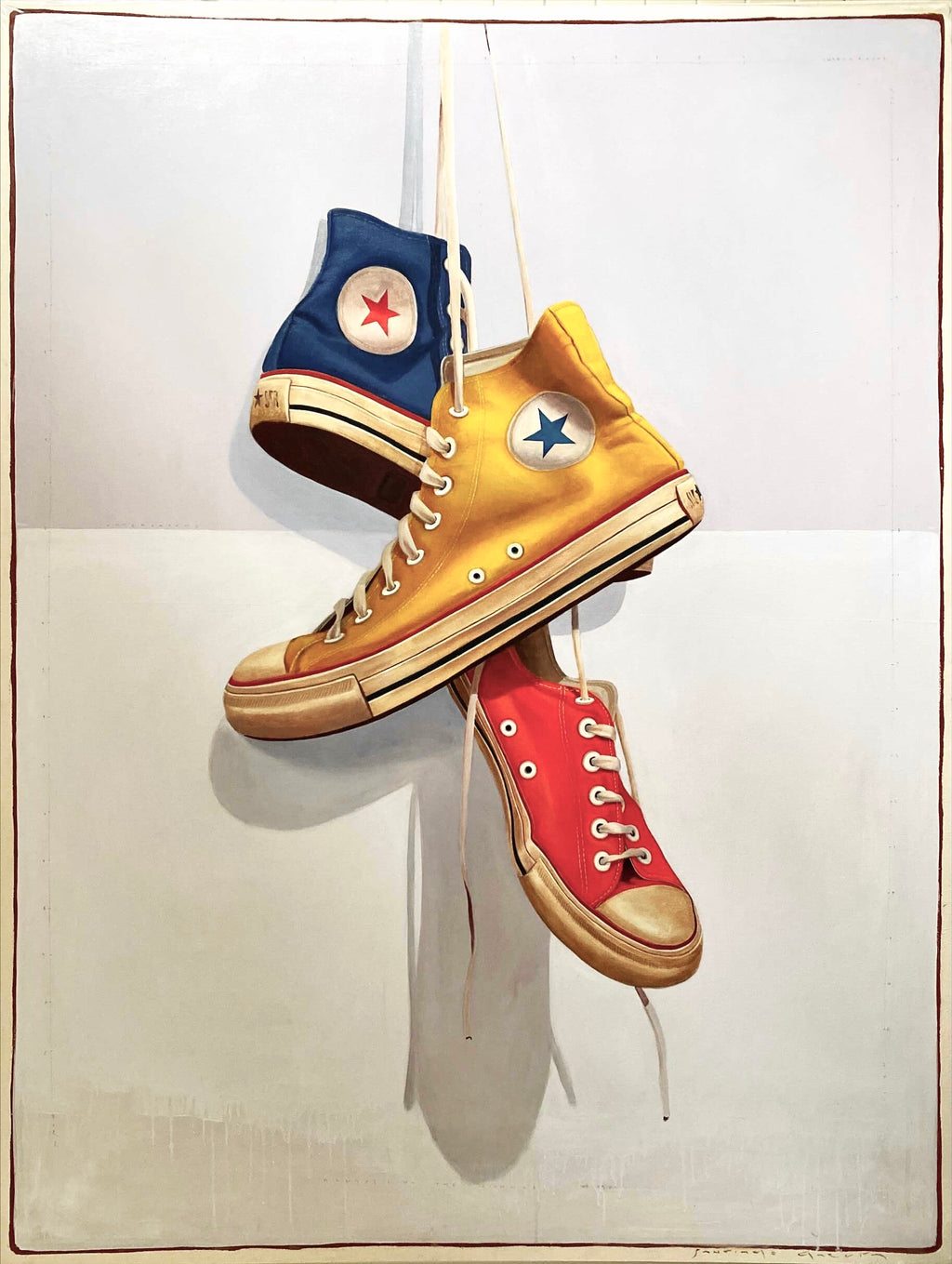 oil painting of vintage blue, yellow, and red converse sneakers hanging by laces on two toned blackground