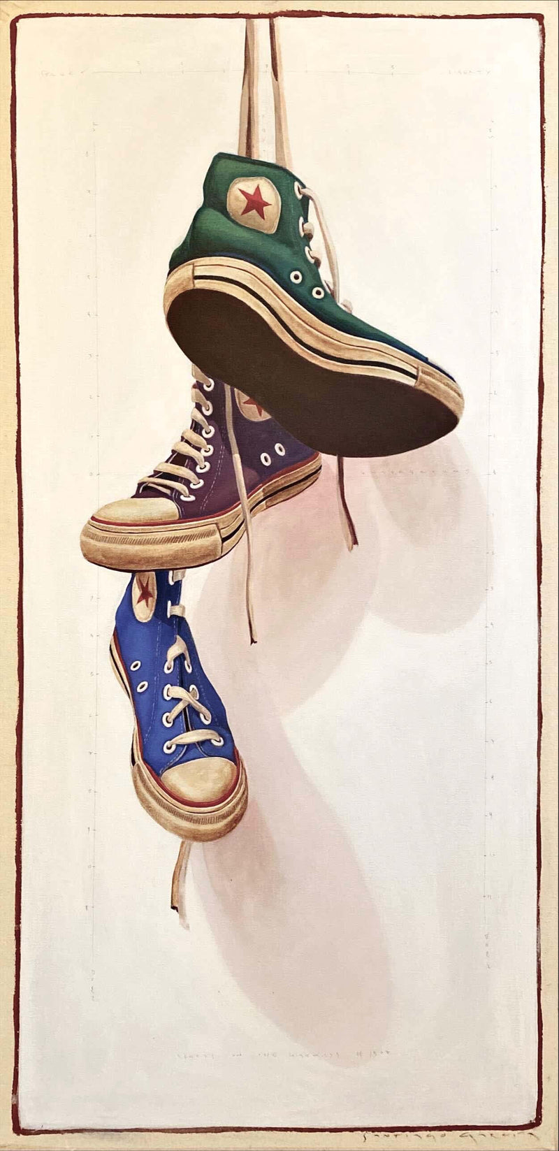 vintage colored converse sneakers in green, purple, and blue hanging by laces in front of off-white background