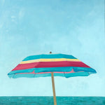 small scale oil painting of pink, yellow and turquoise beach umbrella with blue sky and ocean behind 