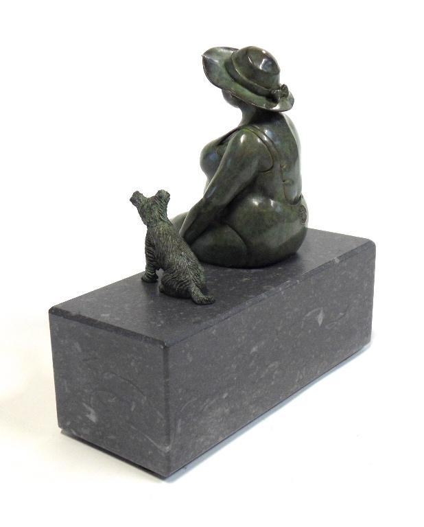 Bronze sculpture by Veronique Clamot of a plus sized model sat on a bench next to a small dog wearing a sunhat