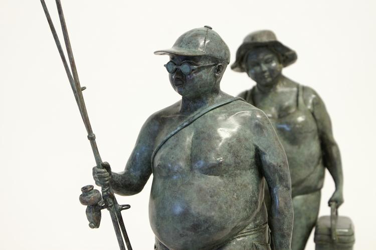 Bronze sculpture by Veronique Clamot of two plus size women walking with fishing gear in hands
