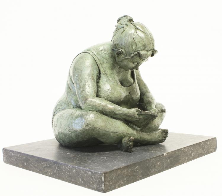 bronze sculpture of a plus-sized woman sitting cross-legged reading a book